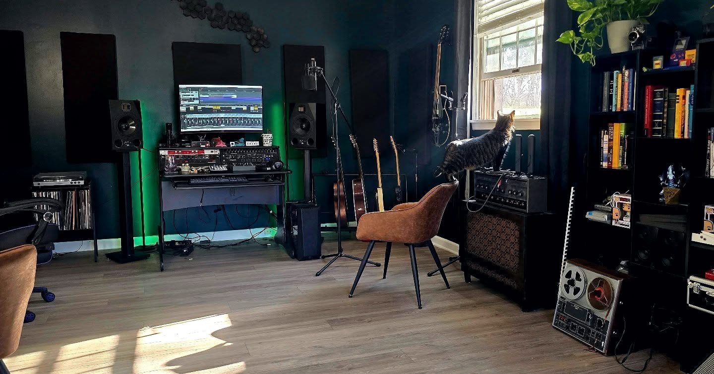 The AboveTheSun mix room in daylight: monitors, outboard rack, guitars, and the tape deck